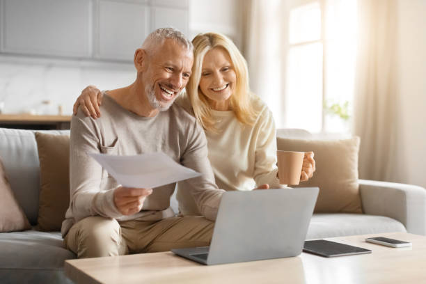 istock Happy couple of pensioners sitting using computer at home 2153371063