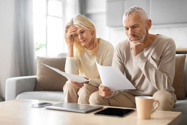 istock Senior Couple Checking Financial Documents, Sitting On Couch At Home 2153371091
