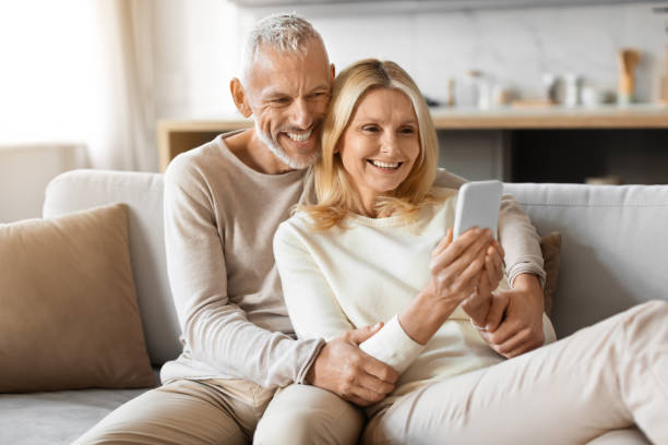 istock Happily married senior couple scrolling on social media, using phone 2153371092