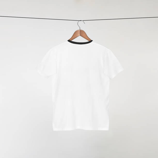 istock Blank White T-Shirts Mockup Hanging on Grey Wall: 3D Rendering 2153371191