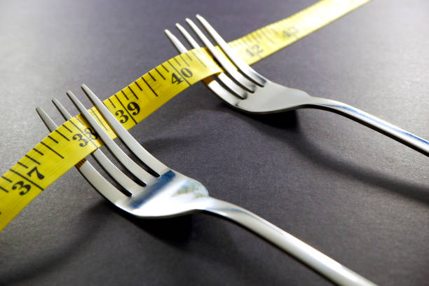 istock Silver fork set together with measuring tape close up view 2153371438