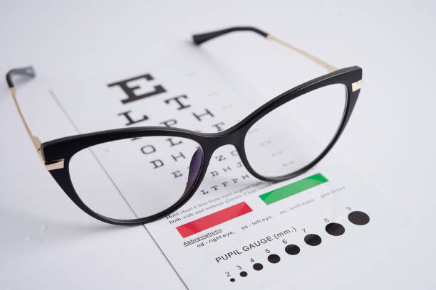 istock Glasses on eye exam chart to test eyesight accuracy of reading. 2153372573