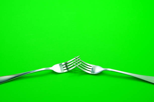 Silver fork set together isolated on green background close up view