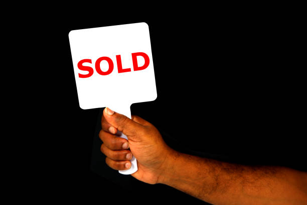istock SOLD hand holding board with black background close-up view copy space 2153374249