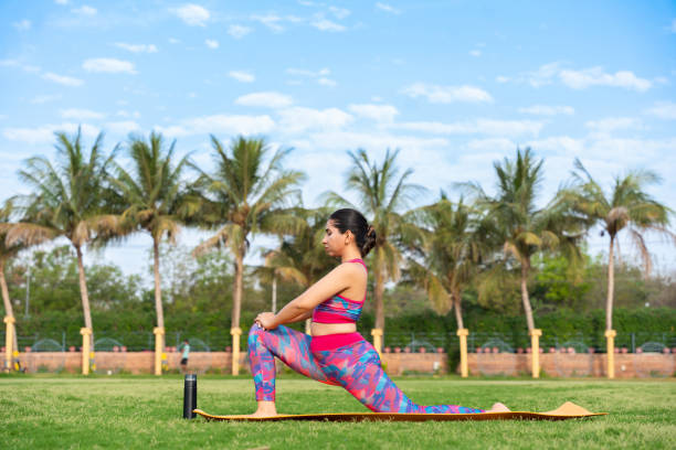 istock Young indian woman doing leaning forward fold Yoga Pose in her garden. exercise, well being, wellness, workout, meditation, mental health concept. 2153374671