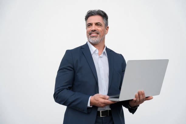 istock Middle age mature businessman using pc laptop for business work application. Smiling handsome older man in formal suit holding computer gadget, looking aside. Isolated white background with copy space 2153377136
