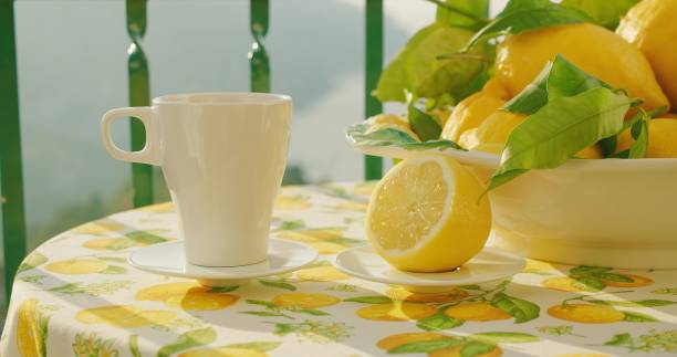 istock A pristine cup of hot tea sits next to a cut lemon on a table outdoors. The serene scene shows beverage amidst abundant lemons on a vivid textile. 2153377256