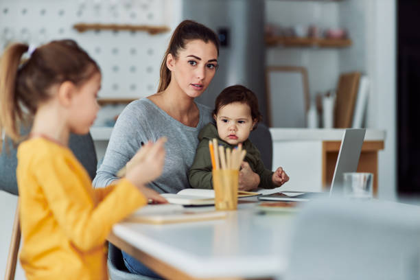 istock A worried single mother watching over her two children cautiously while working from home 2153382547