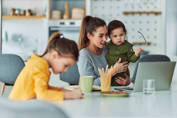 istock A dedicated single mother working from home using a laptop and watching over her two small kids 2153382629