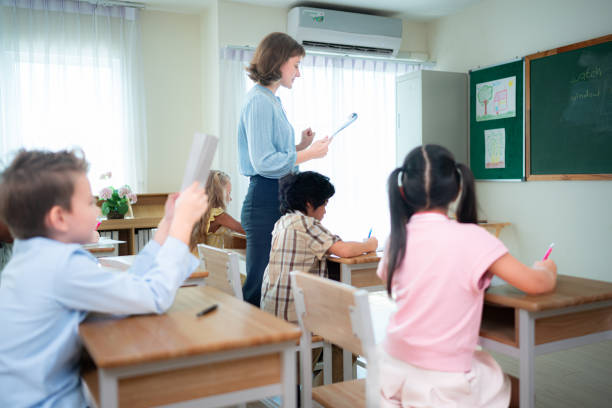 istock Teacher and students, Learn and study in a classroom of school where youngsters sit and listen attentively. 2153382976