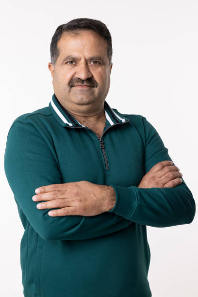 istock Happy mature man with arms crossed and looking at camera while standing against white background 2153383843