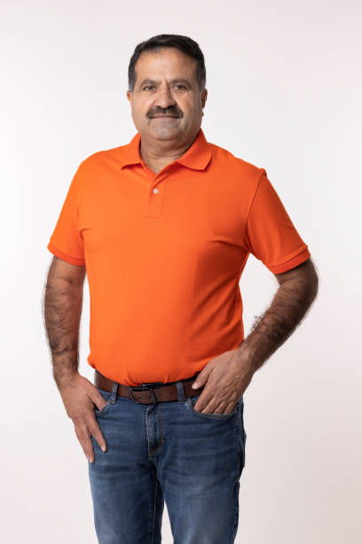 istock Happy mature man with arms crossed and looking at camera while standing against white background 2153383923