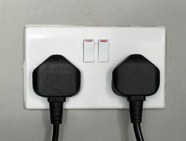 istock Generic, British, dual three pin, domestic electric plug socket with two black plugs 2153385487