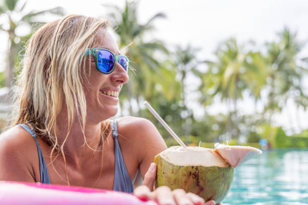 istock Woman Relaxing with Coconut Drink by the Pool 2153386090