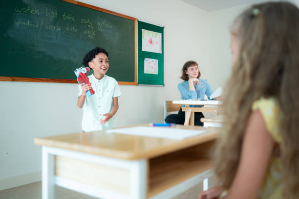 Children with classroom presentation activities in front of the classroom