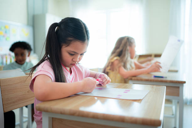 Students learn and study in a classroom of school where youngsters sit and listen attentively.