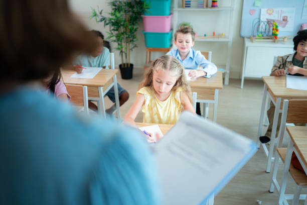 istock Teacher and students, Learn and study in a classroom of school where youngsters sit and listen attentively. 2153389201