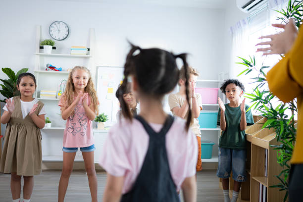 istock Teacher and students, Standing applause to congratulate one student in the class. 2153393267