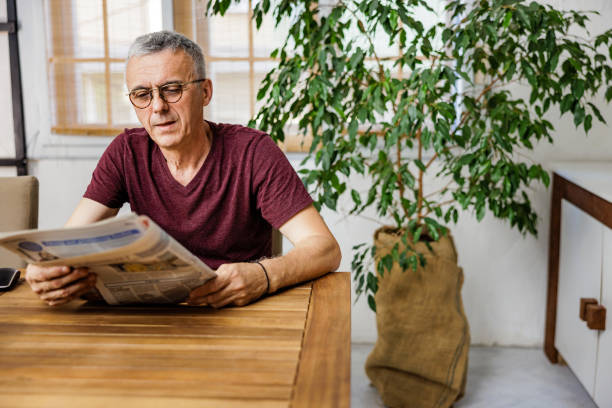 istock Mature man reading newspapers at home 2153393756