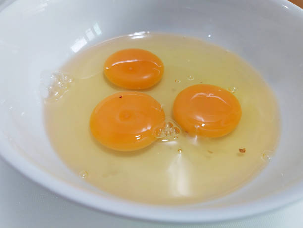 istock Prepare the food by cracking fresh eggs into a white bowl. 2153395285