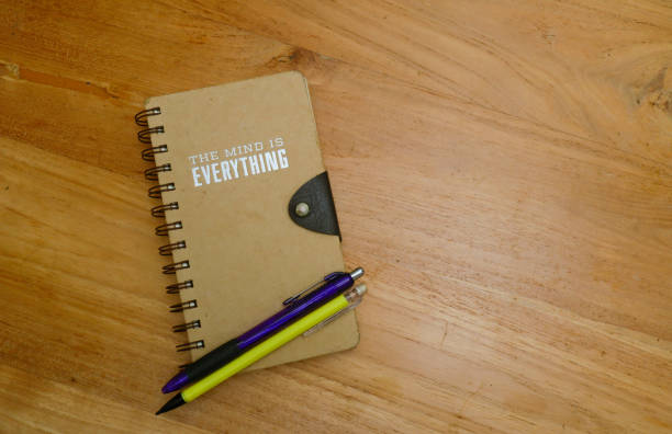 notebook and pen over wooden background