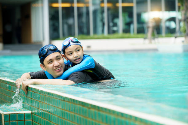 istock Father and son swimming together. 2153401009