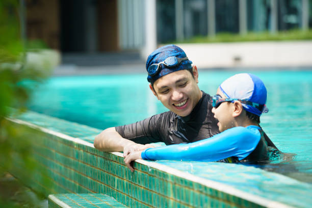 istock Father and son swimming together. 2153401015