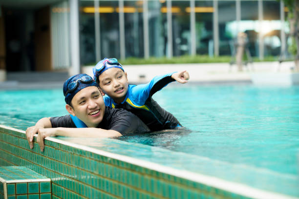 istock Father and son swimming together. 2153401019