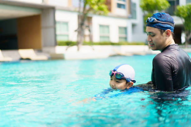 istock Father and son swimming together. 2153401027