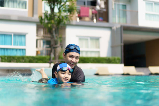 istock Father and son swimming together. 2153401029