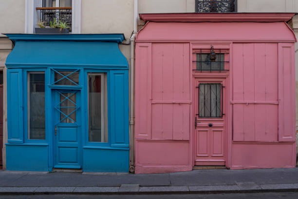 istock Paris, France - 05 11 2024: View of typical blue and pink windows shop converted into apartments 2153402824