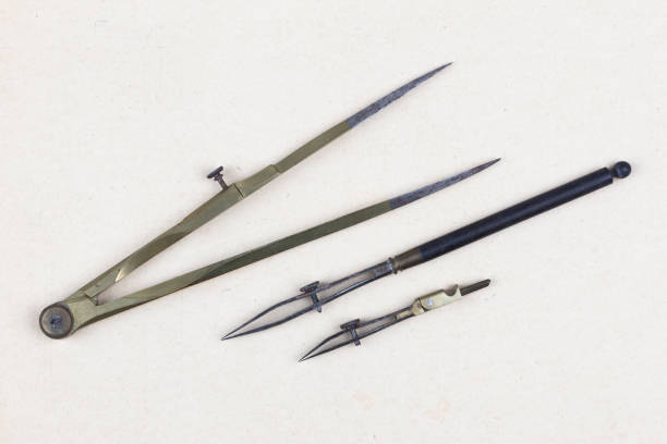 Vintage retro ruling pen with vintage bronze dividers calipers on paper background