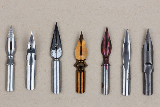 Metal nibs on an antique textured paper background.
