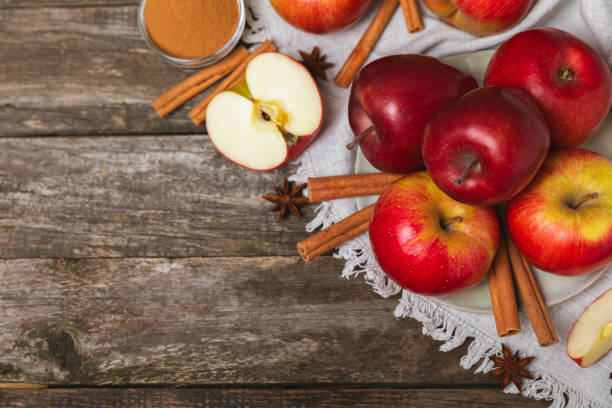 istock Apples with cinnamon on background. Fragrant red spiced apples with cinnamon sticks and star anise. Apple slices with spicy spices. Place for text. Copy space. Harvesting. Fruits. 2153403796