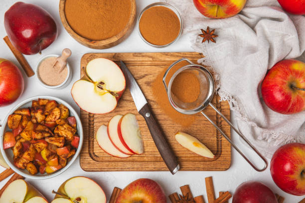 istock Apples with cinnamon on background. Fragrant red spiced apples with cinnamon sticks and star anise. Apple slices with spicy spices. Place for text. Copy space. Harvesting. Fruits. 2153403817