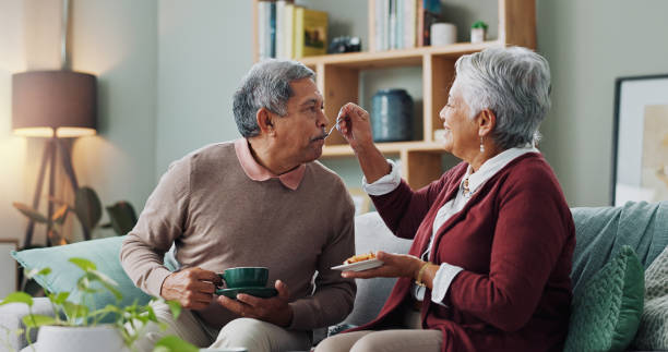 istock Home, cake and elderly couple with coffee for love, bonding and funny conversation on sofa. Senior people, happy and relax with dessert for afternoon communication, discussion and peace in retirement 2153405946