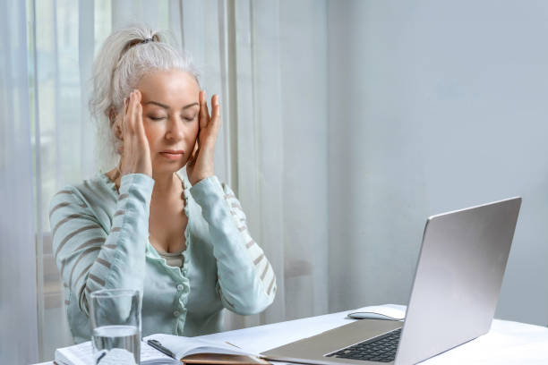 istock An elderly woman suffers from fatigue and headaches from working at the computer for a long time. 2153406304