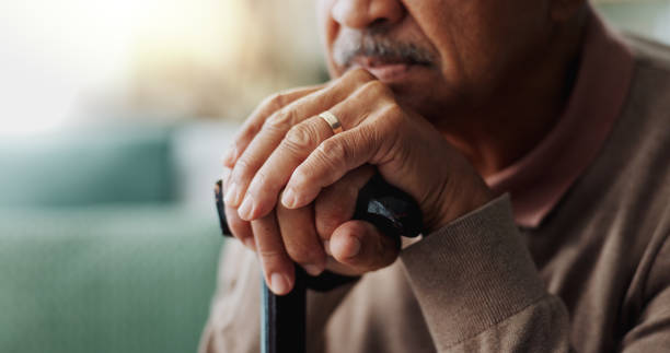 istock Old man, hands and walking stick in home for retirement grief for remember nostalgia, memory or thoughts. Male person, cane and wedding ring for elderly widower or unhappy, contemplating or lonely 2153406782