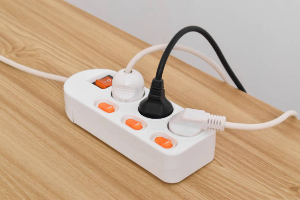 istock Electrical plug in outlet socket at home isolated on on wooden table 2153407476