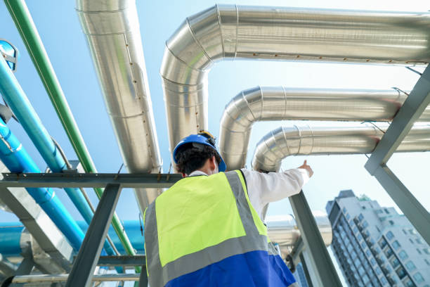 istock Industrial engineer adjusting pipeline valve with radio communication on construction site. Engineer on urban construction site using radio to coordinate with team on a sunny industrial rooftop. 2153408586