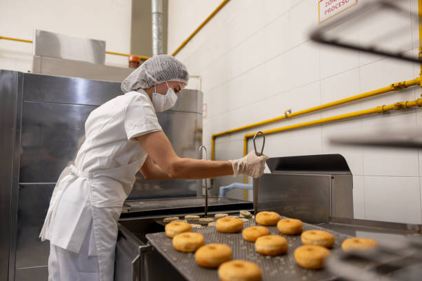istock Employee working at an industrial bakery frying donuts 2153409148