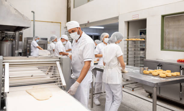 istock Employees working in the production line at an industrial bakery 2153409161