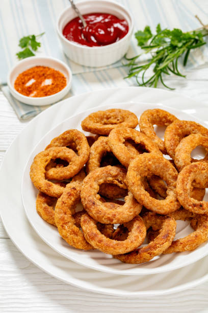 istock deep fried crispy onion rings on white plate 2153411790