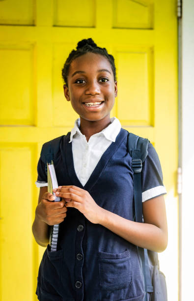istock Cute young African American elementary school student ready for school stands outside her home on the first day 2153413308