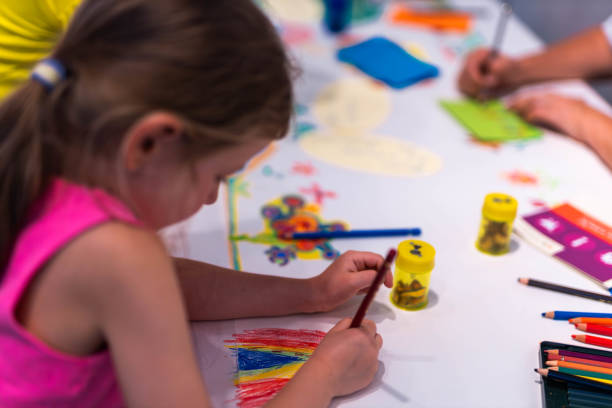 istock Child girl draws with colored pencils 2153414658