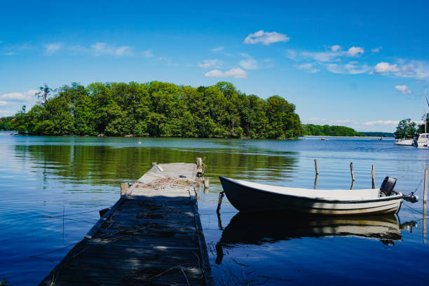 Morning atmosphere on a calm lake in Mecklenburg-Vorpommern, View over anchor of sailboat to anchored motor boats