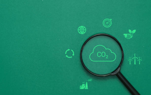 istock co2 emission reduction symbol in the magnifying glass, climate change limiting global warming and sustainable development, and green business concepts, Environmental protection and the concept of co2 2153416550