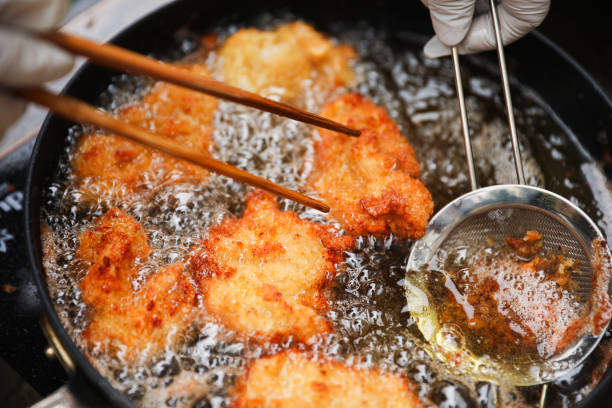 istock golden, crispy fried chicken pieces in bubbling oil, symbolizing indulgence and temptation 2153422246