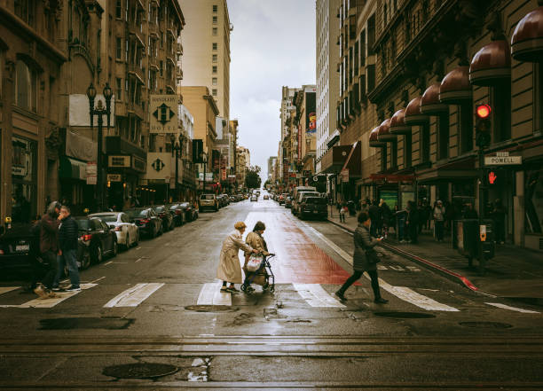 Supporting elderly people crossing the street in San Francisco, California, USA