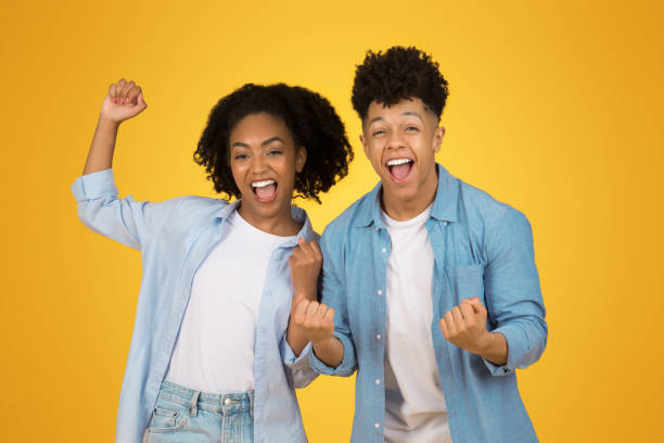 istock Two exuberant young adults celebrate with raised fists and bright smiles 2153424521